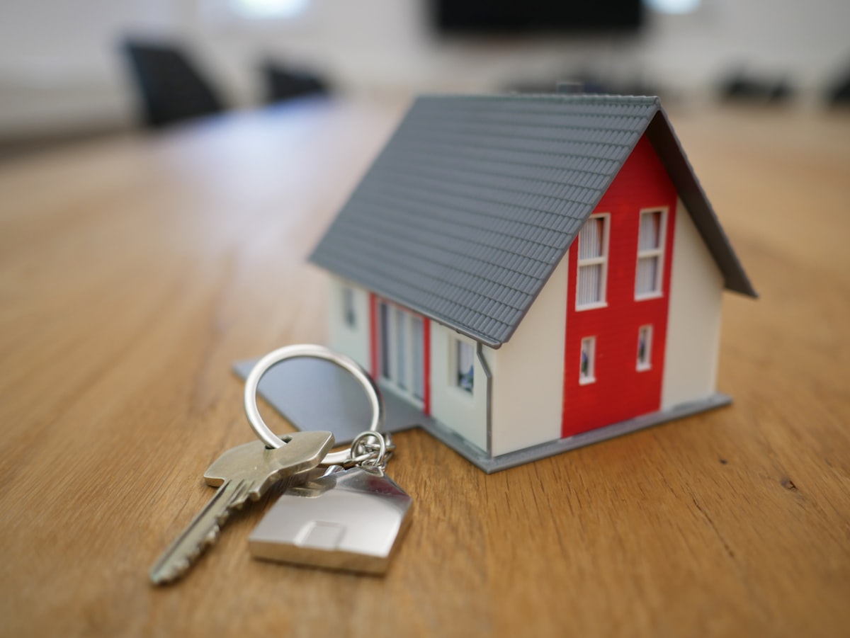 Keys and house model on a desk representing buying guide